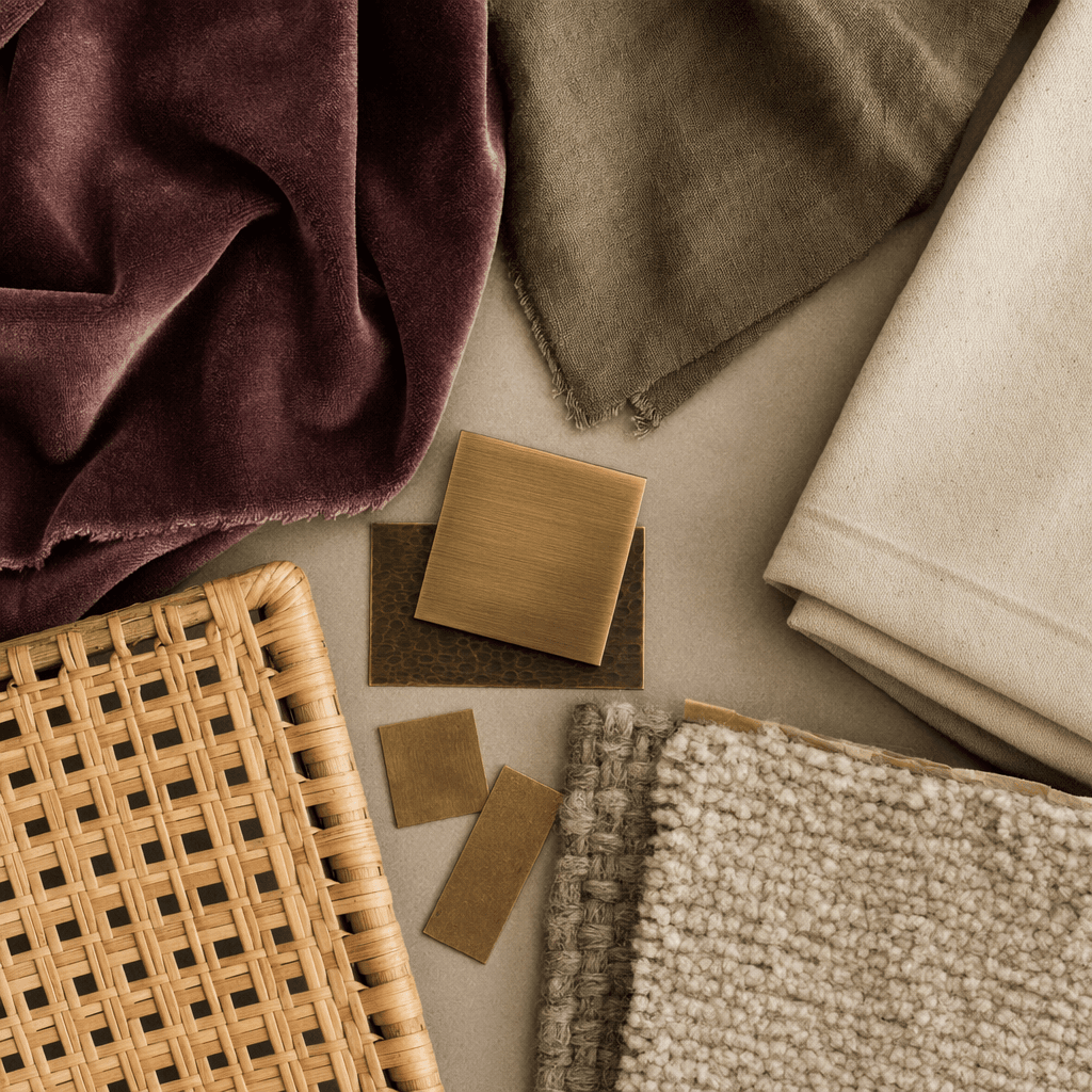 Flat lay of mulberry velvet, olive linen, cream canvas, brass chips and wool samples